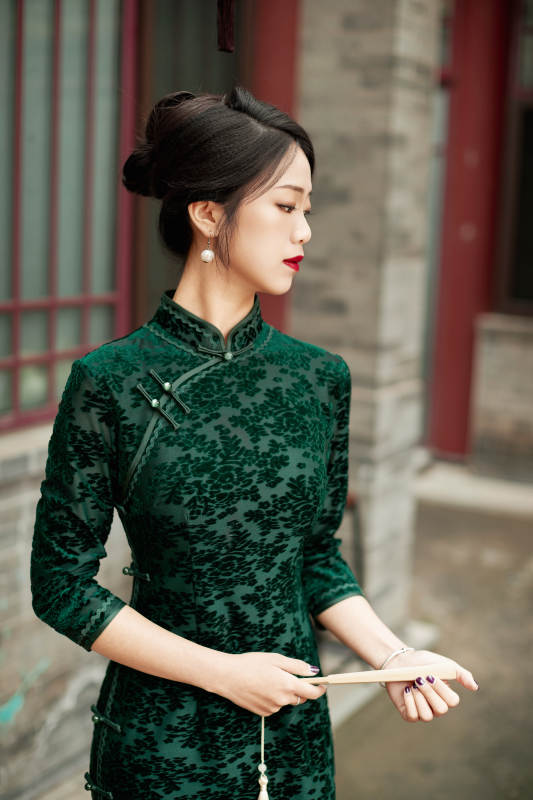 在中式庭院里身穿复古旗袍的亚洲女性