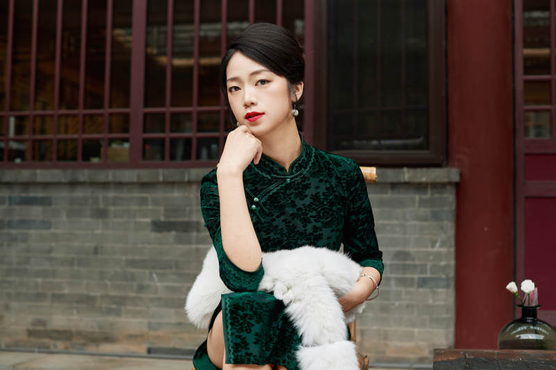 在中式庭院里身穿复古旗袍的亚洲女性