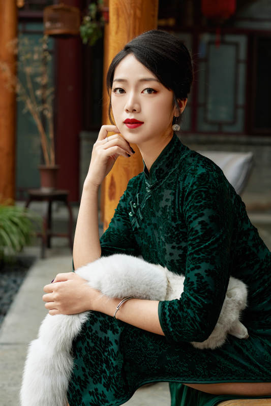 在中式庭院里身穿复古旗袍的亚洲女性