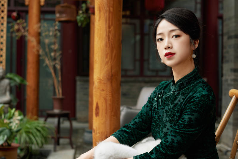 在中式庭院里身穿复古旗袍的亚洲女性