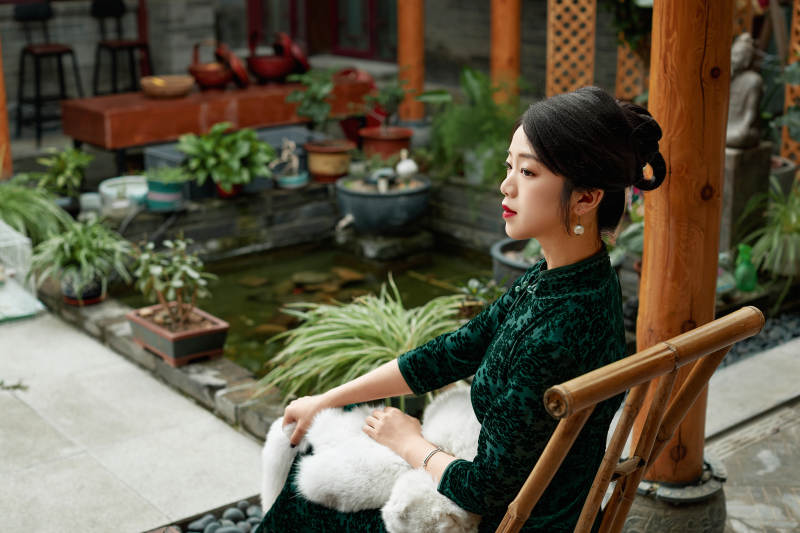 在中式庭院里身穿复古旗袍的亚洲女性
