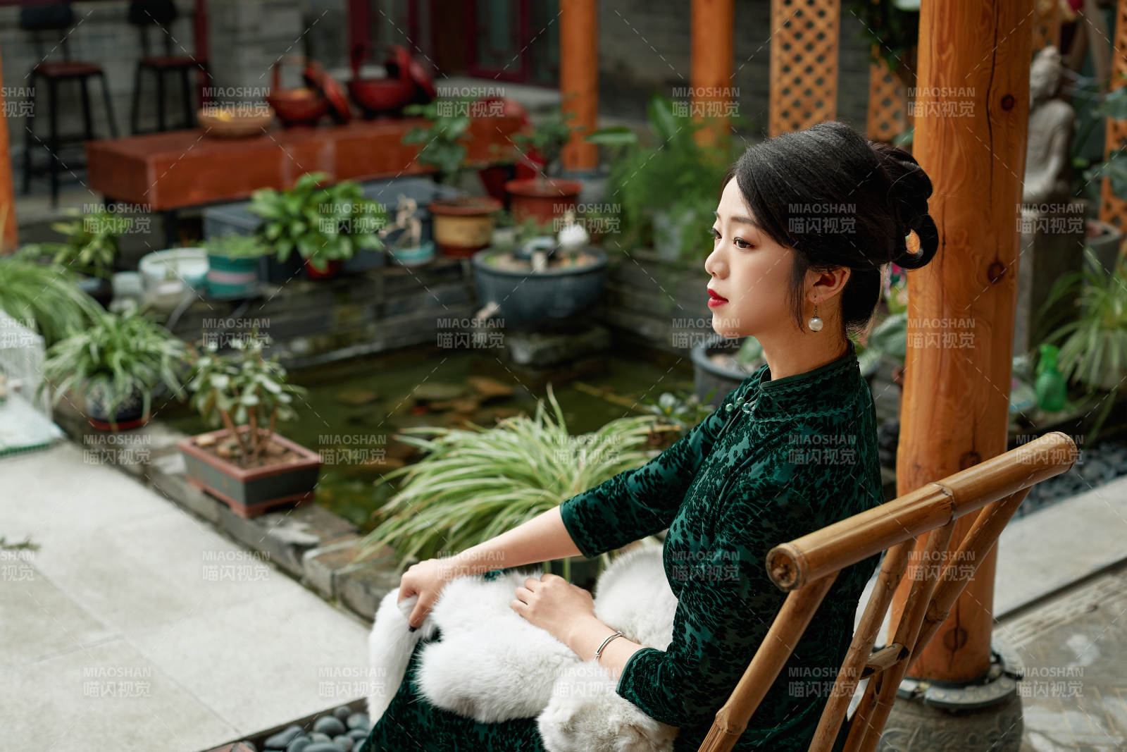 在中式庭院里身穿复古旗袍的亚洲女性