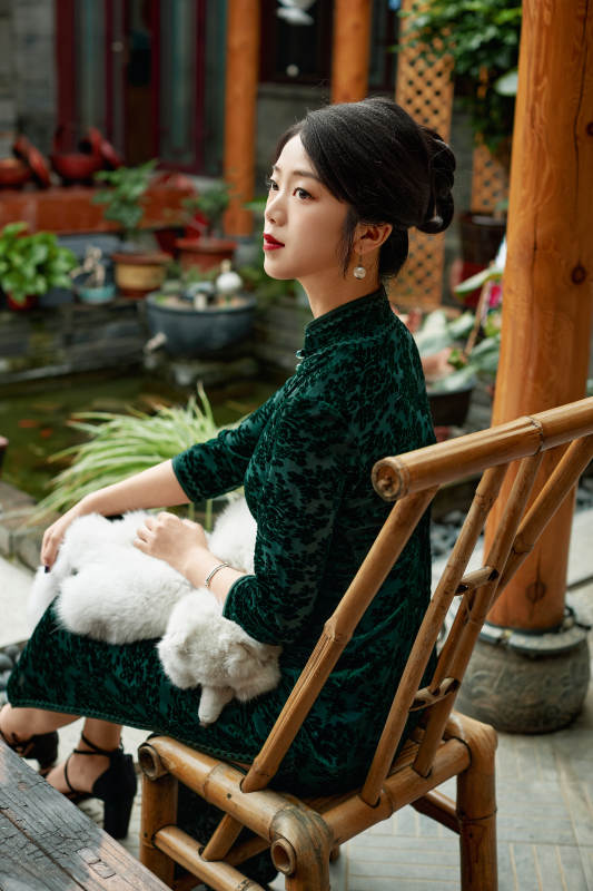 在中式庭院里身穿复古旗袍的亚洲女性