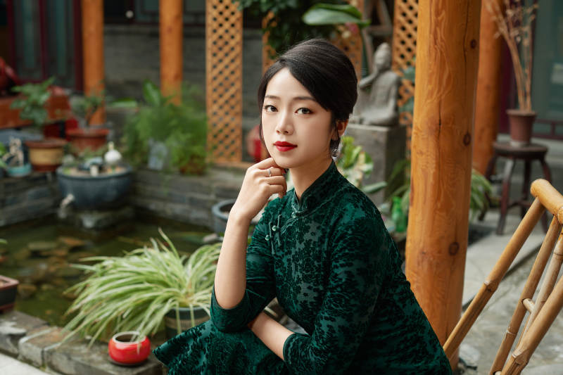 在中式庭院里身穿复古旗袍的亚洲女性