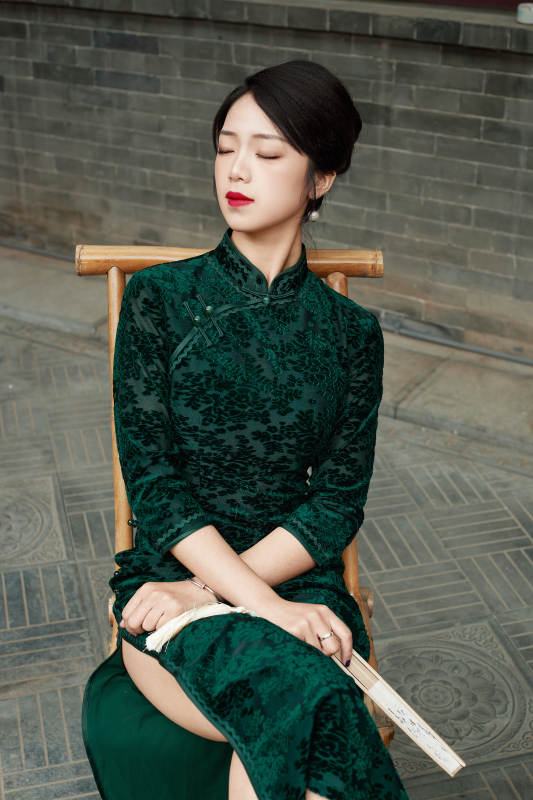 在中式庭院里身穿复古旗袍的亚洲女性