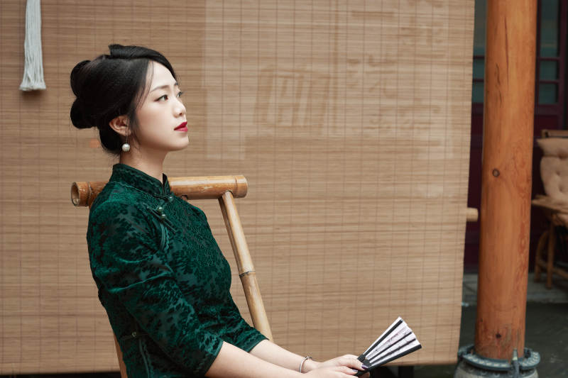 在中式庭院里身穿复古旗袍的亚洲女性