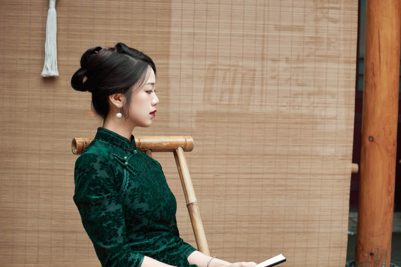 在中式庭院里身穿复古旗袍的亚洲女性