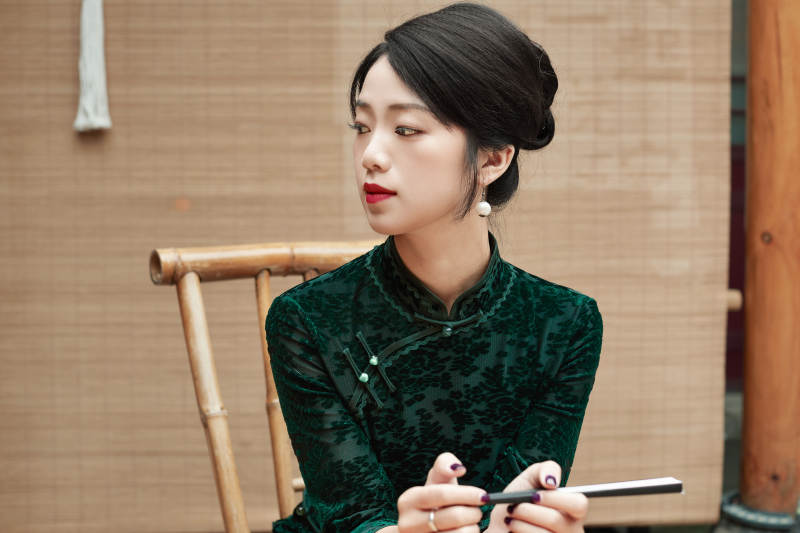 在中式庭院里身穿复古旗袍的亚洲女性