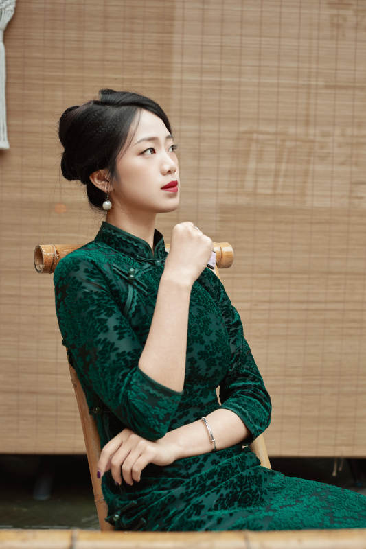 在中式庭院里身穿复古旗袍的亚洲女性