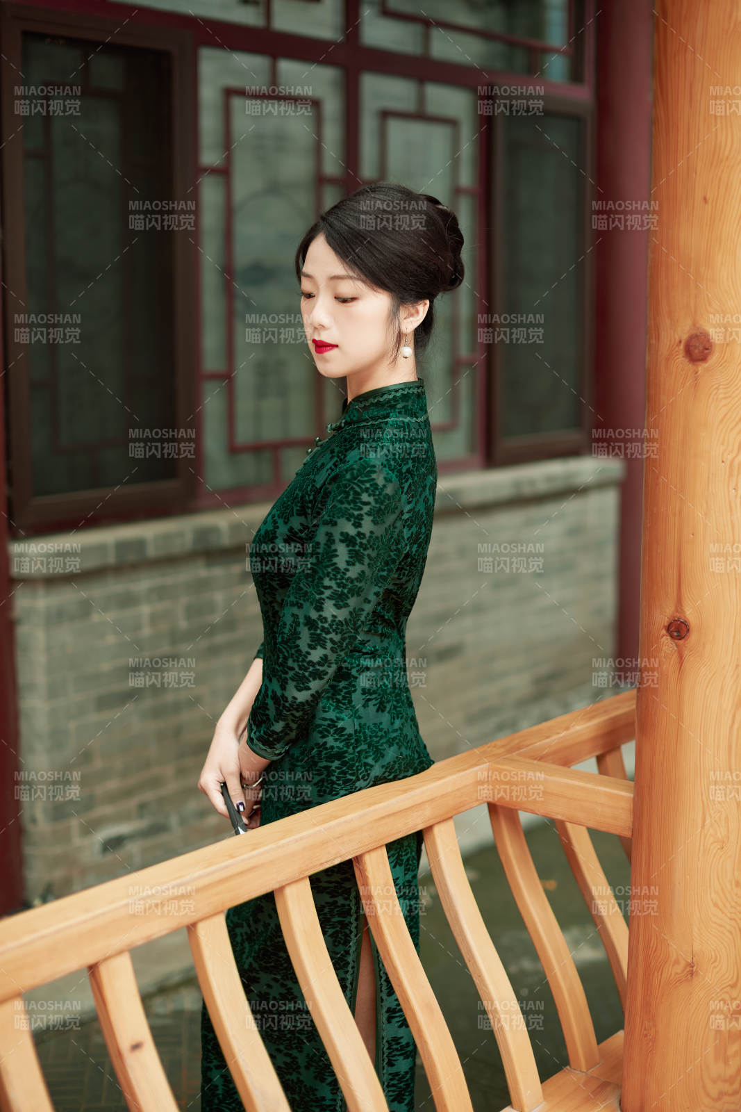 身穿旗袍在庭院散步的年轻美女