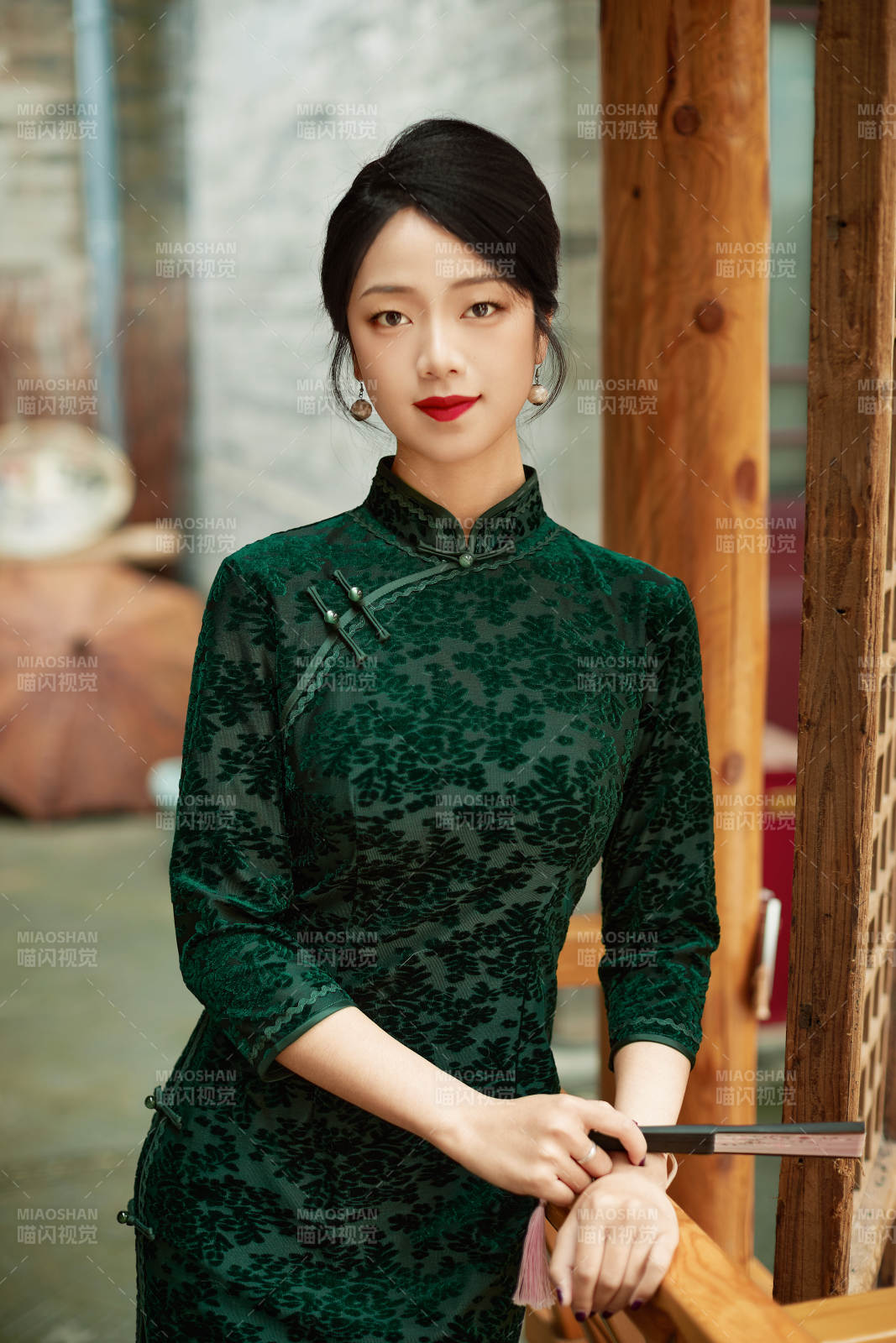 身穿旗袍在庭院散步的年轻美女