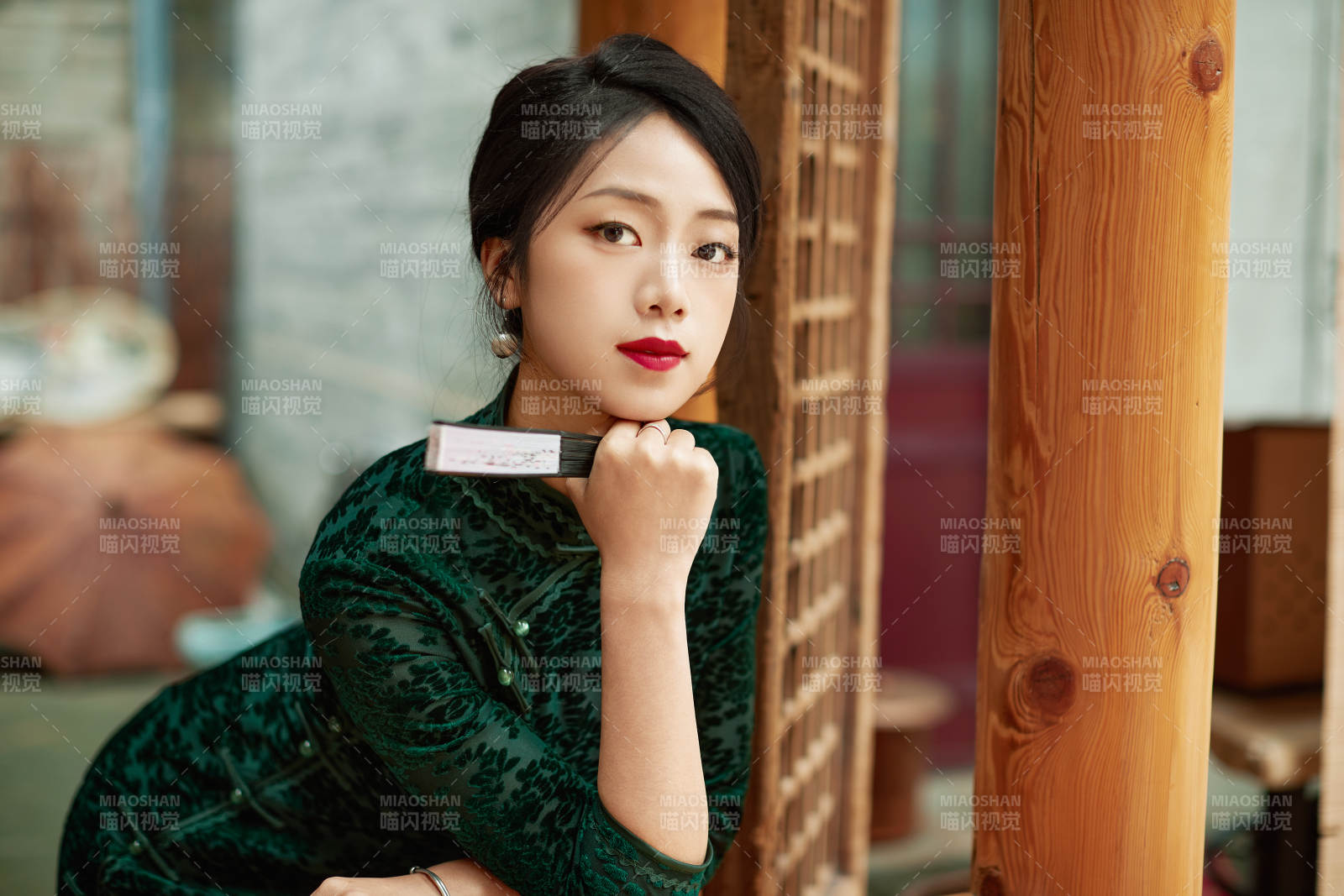 身穿旗袍在庭院散步的年輕美女