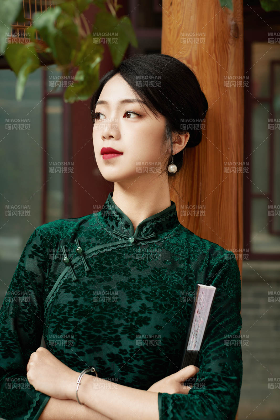 身穿旗袍在庭院散步的年轻美女