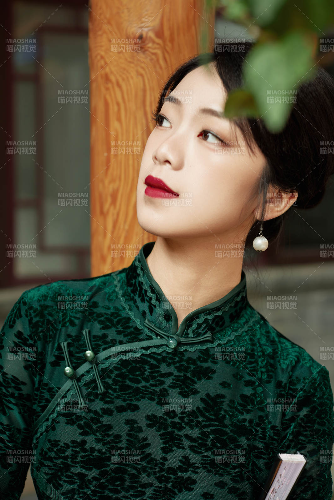 身穿旗袍在庭院散步的年轻美女