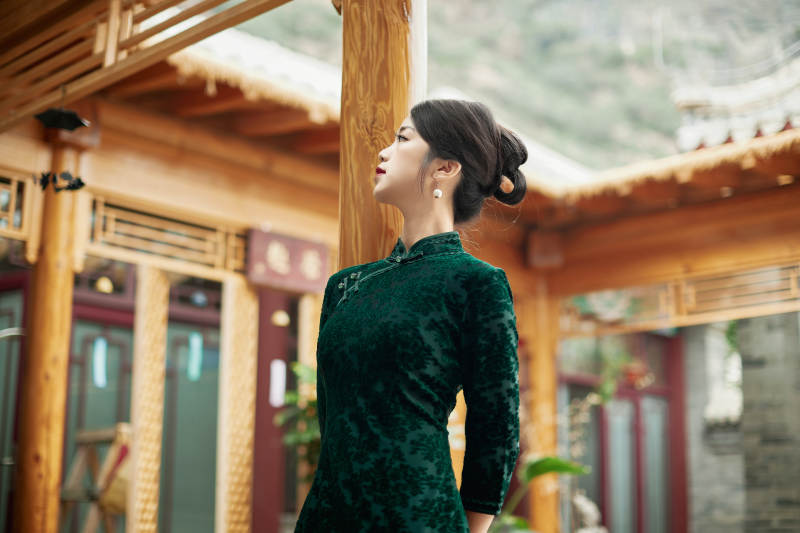 在中式庭院里身穿复古旗袍的亚洲女性