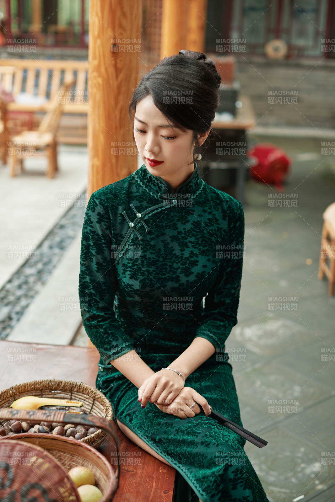 身穿旗袍在庭院散步的年轻美女