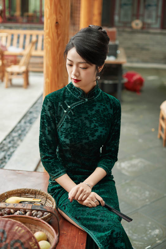 身穿旗袍在庭院散步的年轻美女