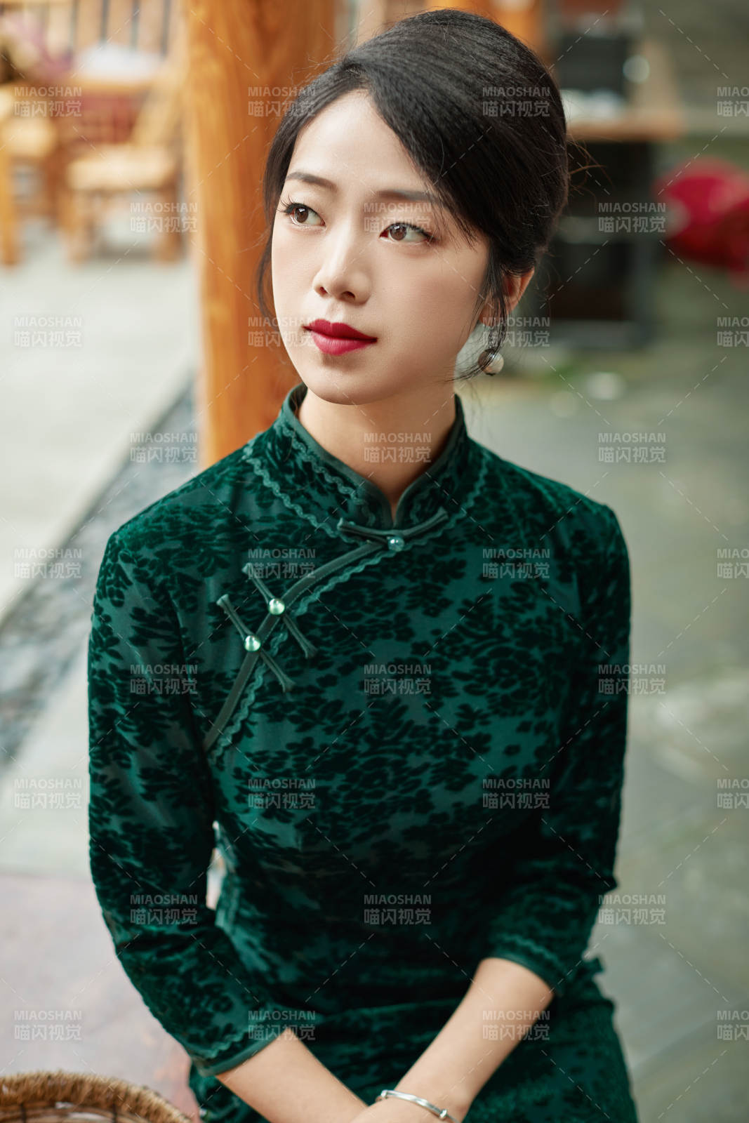 身穿旗袍在庭院散步的年轻美女