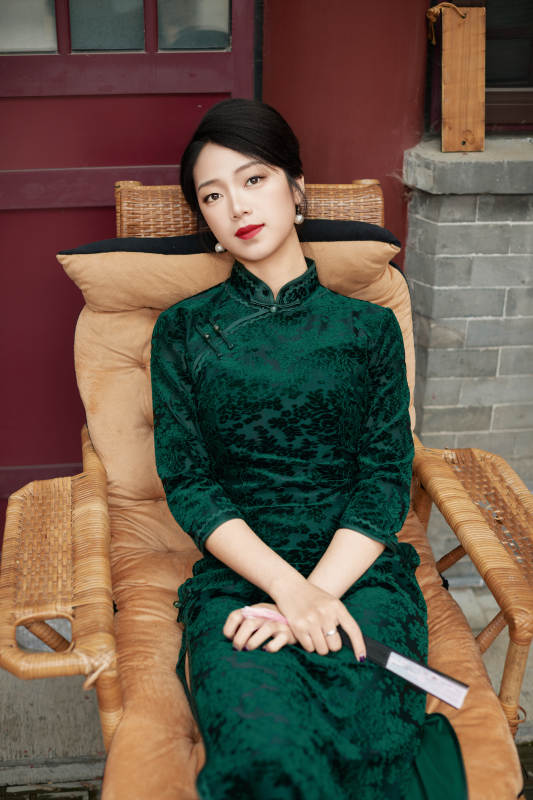 坐在中式庭院里身穿复古旗袍的亚洲女性