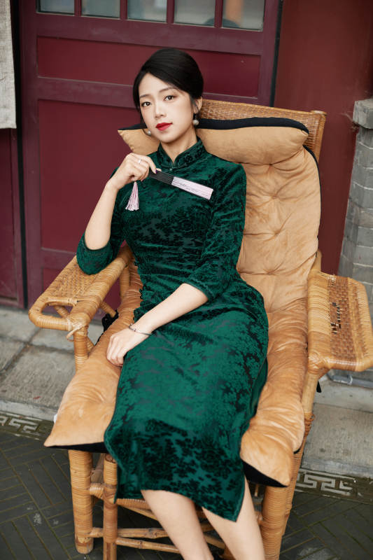 坐在中式庭院里身穿复古旗袍的亚洲女性