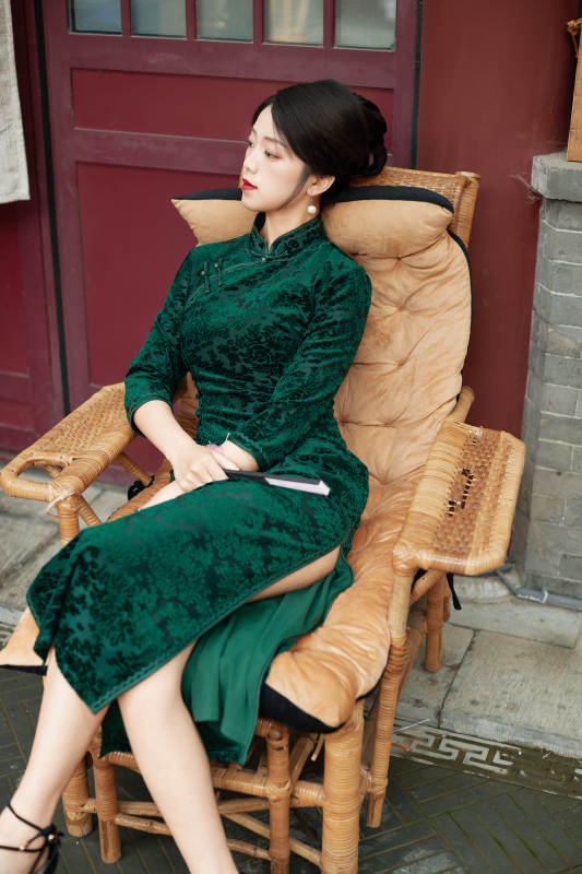 坐在中式庭院里身穿复古旗袍的亚洲女性