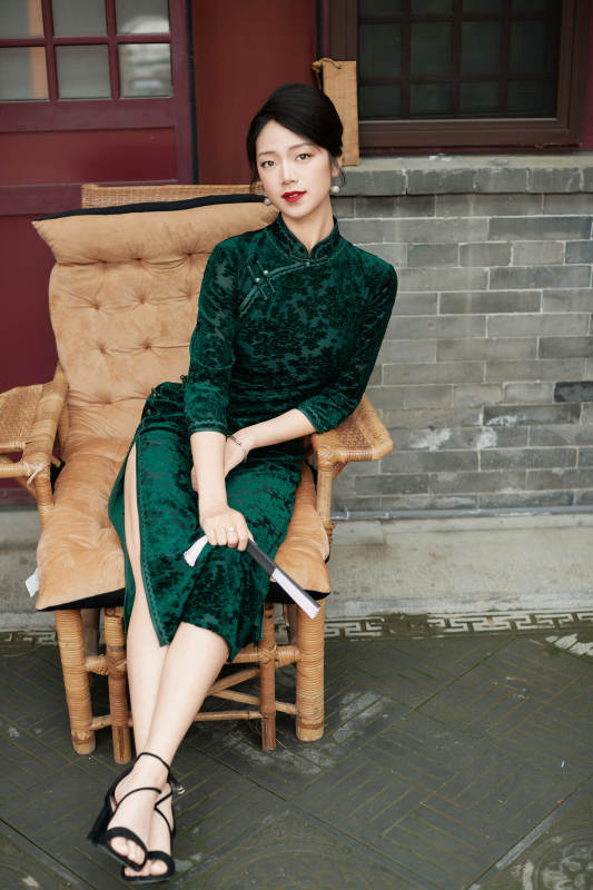 坐在中式庭院里身穿复古旗袍的亚洲女性