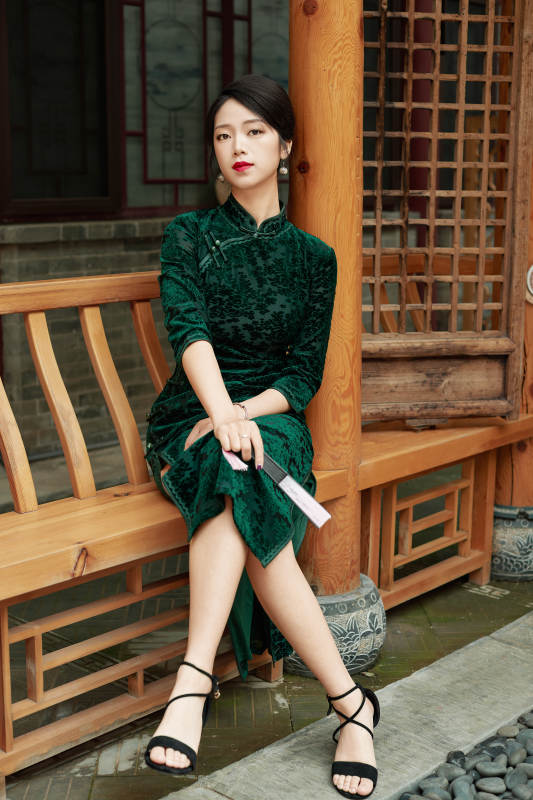 坐在中式庭院里身穿复古旗袍的亚洲女性