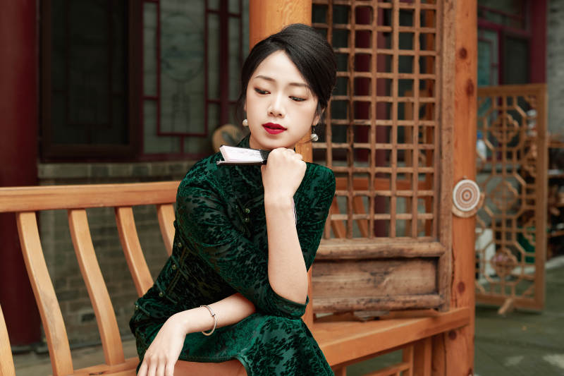 在中式庭院里身穿复古旗袍的亚洲女性