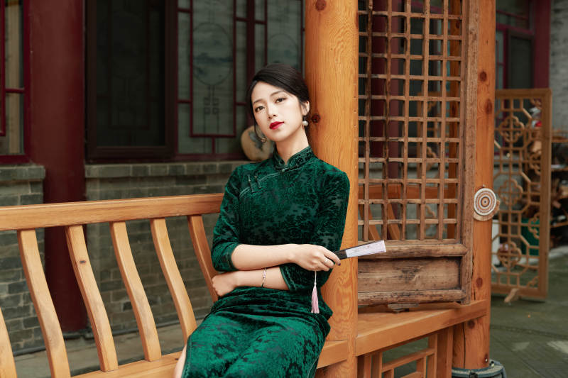 在中式庭院里身穿复古旗袍的亚洲女性