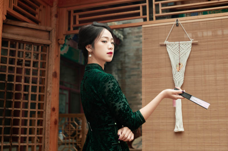 在中式庭院里身穿复古旗袍的亚洲女性