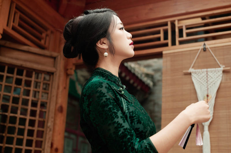 在中式庭院里身穿复古旗袍的亚洲女性