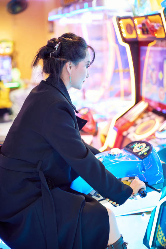 周末在电子游戏娱乐城玩摩托车游戏的美女