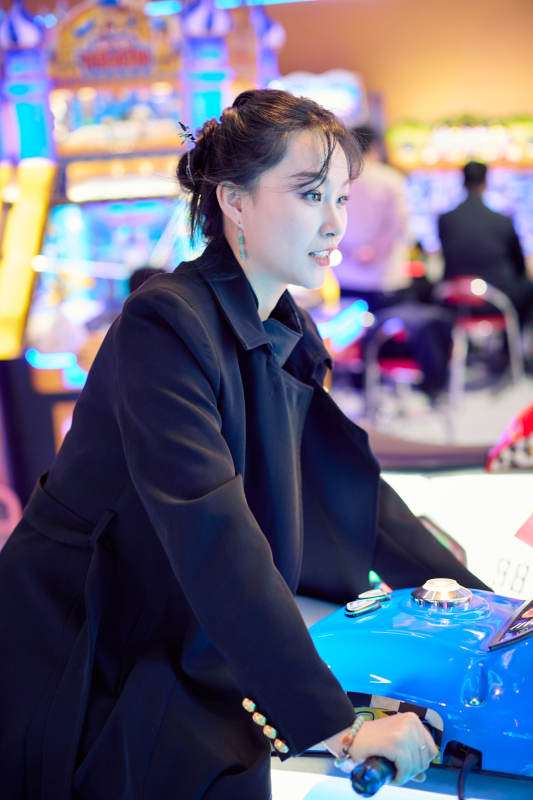 周末在电子游戏娱乐城玩摩托车游戏的美女