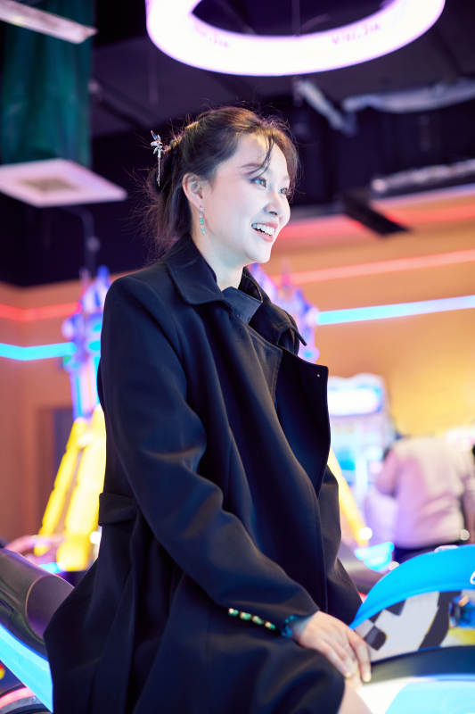 周末在电子游戏娱乐城玩摩托车游戏的美女