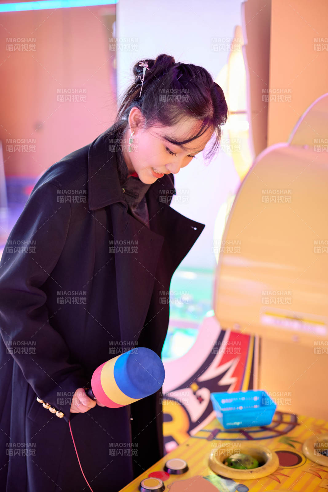 在电子娱乐城玩打地鼠游戏的美女