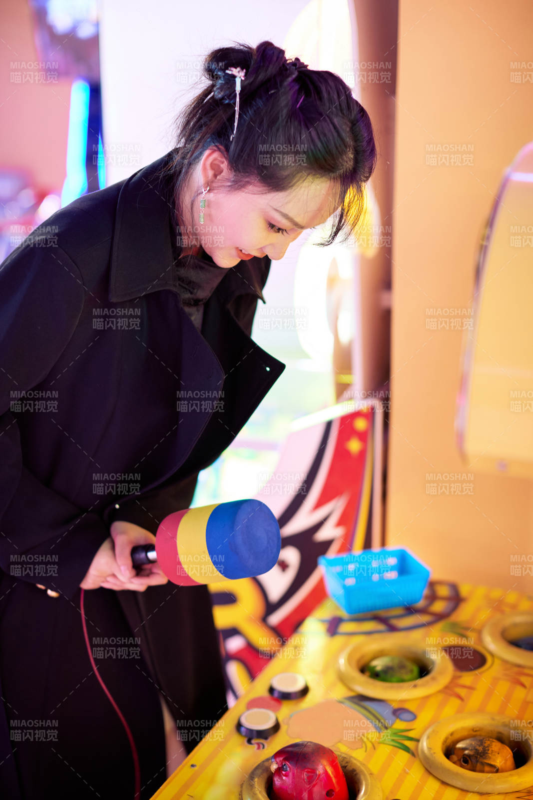 在电子娱乐城玩打地鼠游戏的美女