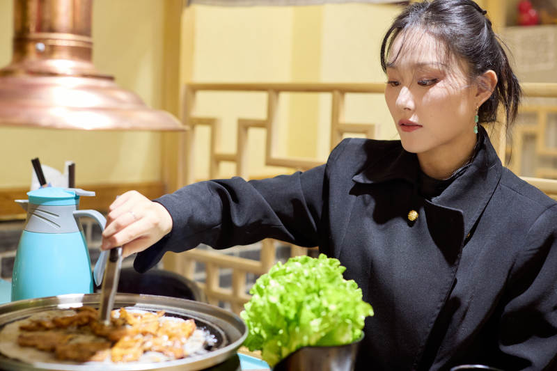 在韩式烤肉店享受美食的亚洲美女