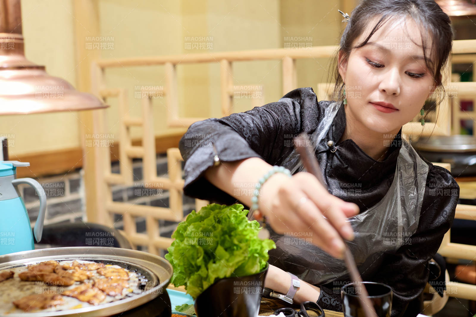 在韩式烤肉店享受美食的亚洲美女