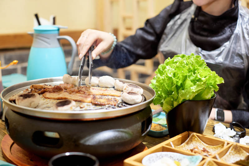 在韩式烤肉店享受美食的亚洲美女