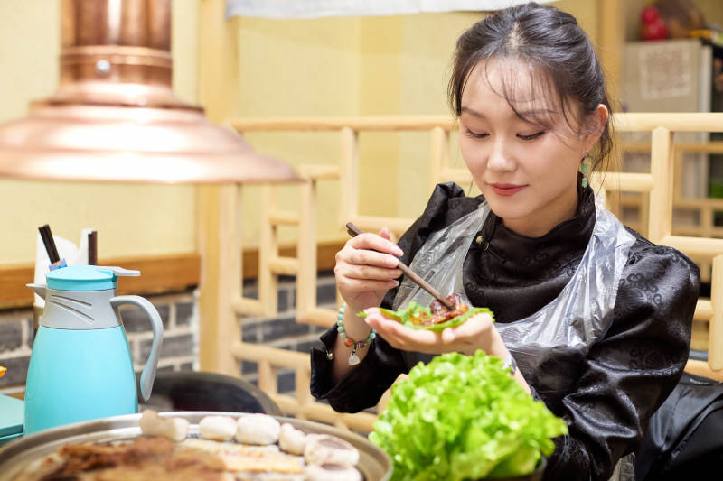 在韩式烤肉店享受美食的亚洲美女