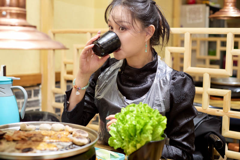 在韩式烤肉店享受美食的亚洲美女