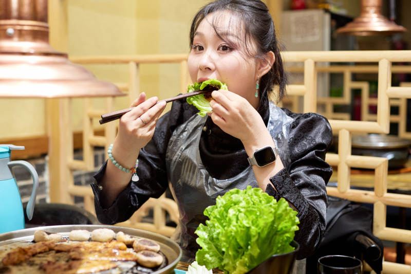 在韩式烤肉店享受美食的亚洲美女