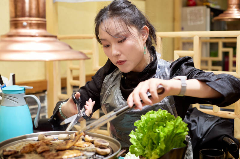 在韩式烤肉店享受美食的亚洲美女