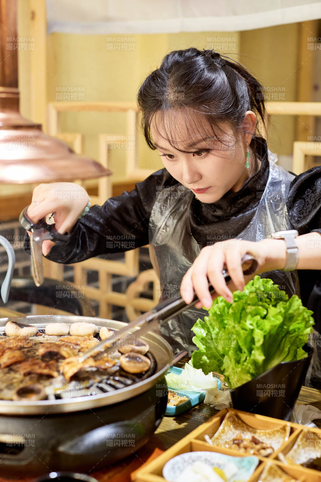 在韩式烤肉店享受美食的亚洲美女