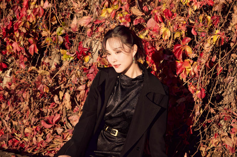 秋天在红叶遍布的河边拍照的亚洲女性