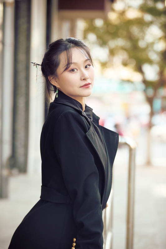 在繁华的街道上拍照的东方女性