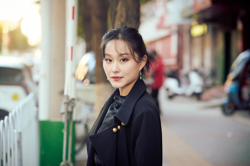 在繁华的街道上拍照的东方女性