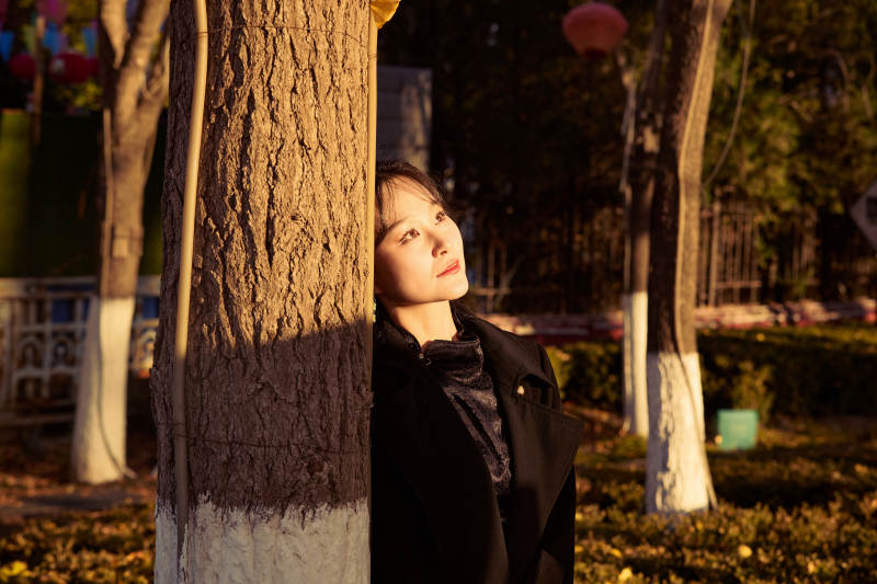 秋季午后在公园里享受阳光的东方美女