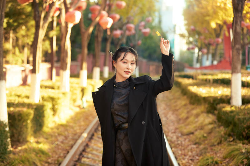 深秋午后在废弃铁轨上拍照的亚洲美女