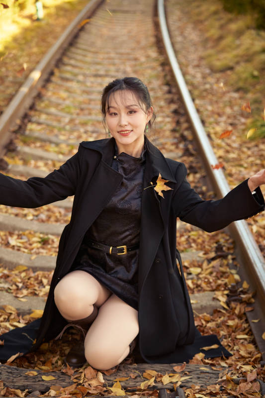 深秋午后在废弃铁轨上拍照的亚洲美女